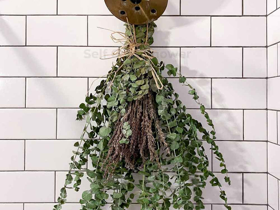 Eucalyptus hanging from shower head with fresh lavender and twine