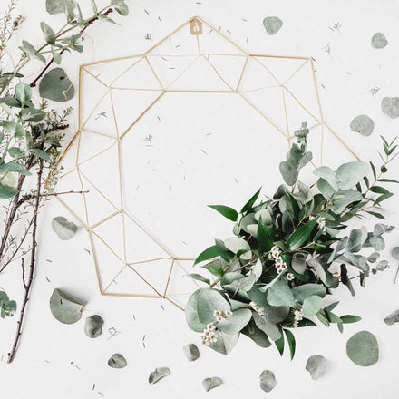 Eucalyptus scattered around white background with yellow design in the middle for a wedding