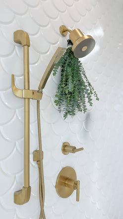 eucalyptus hanging from gold tile showerhead