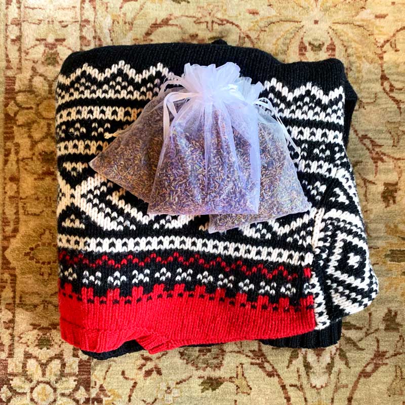 Sweater on carpet with lavender buds pouch of aromatic dried lavender
